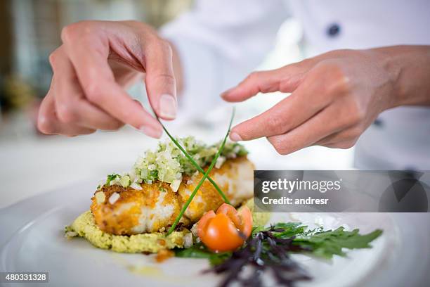 nahaufnahme eines küchenchefs, der einen teller schmückt - beautiful food stock-fotos und bilder