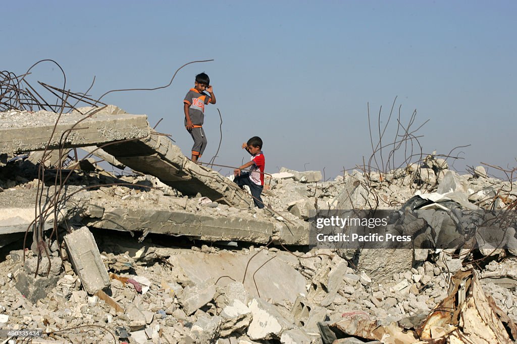 Palestinian boys play on the rubble of houses which...