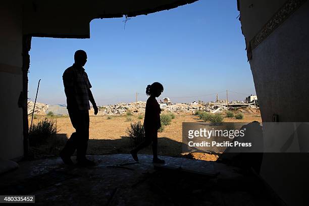 Palestinian Hamada Qudeh and his daughter are inspecting their house which was destroyed during the 50-day Israeli war against Gaza in the summer of...