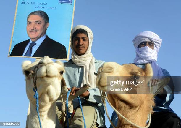 Supporters of Ali Benflis hold up his image as he arrives in to Adrar, 1 400 km southwest of the capital Algiers, as campaigning kicks off in Algeria...