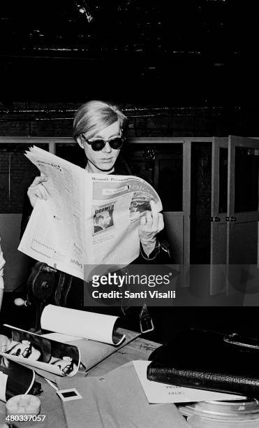 Andy Warhol at the Factory reading a newspaper on January 5, 1967 in New York, New York.