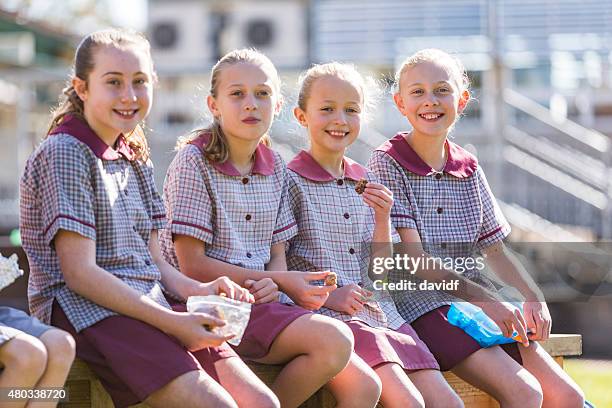 young school children outdoors eating healthy lunch in the sunshine - schoolgirl stock pictures, royalty-free photos & images