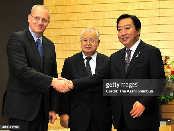 Japan Business Round Table Co-Chair Jean-Yves Le Gall shakes hands with Japanese Prime Minister Yoshihiko Noda while Keidanren President Hiromasa...