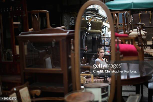 An antique dealer is reflected in a mirror on her stall on July 11, 2015 in Athens, Greece. Greek Prime Minister Alexis Tsipras has won the backing...