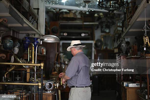 Man peruses items for sale in an antique shop on July 11, 2015 in Athens, Greece. Greek Prime Minister Alexis Tsipras has won the backing of...