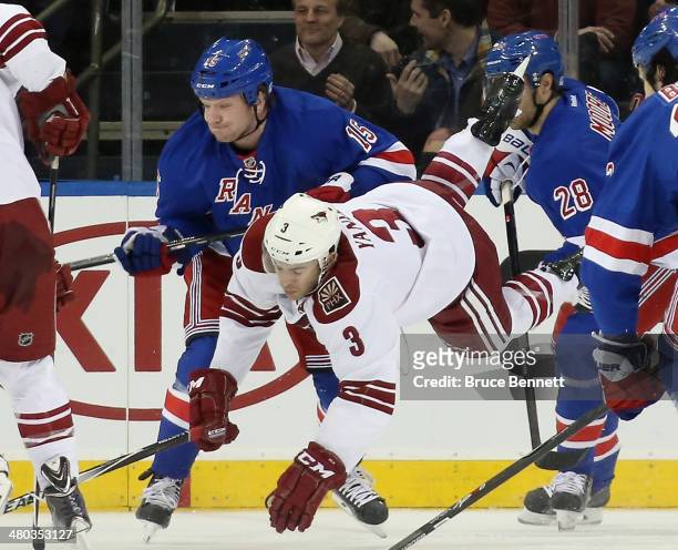 Keith Yandle of the Phoenix Coyotes is tripped up by Derek Dorsett of the New York Rangers during the first period at Madison Square Garden on March...