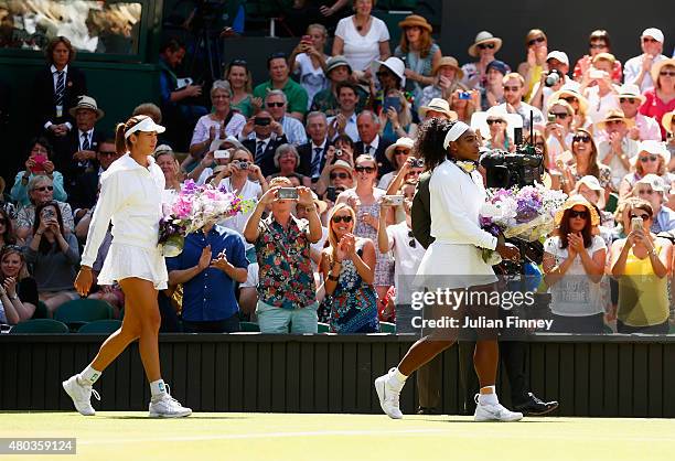Garbine Muguruza of Spain and Serena Williams of the United States enter centre court ahead of the Final Of The Ladies' Singles during day twelve of...
