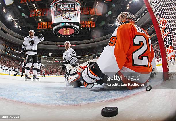 Marian Gaborik and Alec Martinez of the Los Angeles Kings gesture towards goaltender Ray Emery of the Philadelphia Flyers and the loose puck after a...