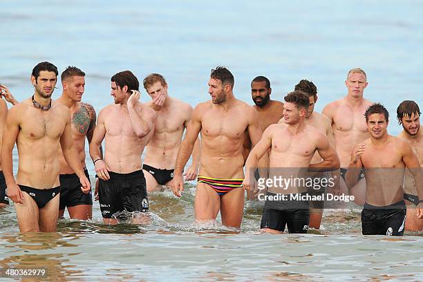Players walk in from the water during a Collingwood Magpies AFL recovery session at St Kilda Sea Baths on March 25, 2014 in Melbourne, Australia.