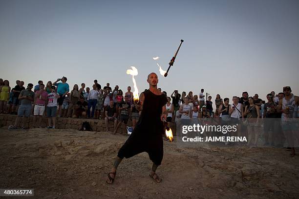 Fire juggler performs at Cafe del Mar in San Antonio de Portmany, on Ibiza Island on July 10, 2015. AFP PHOTO/ JAIME REINA