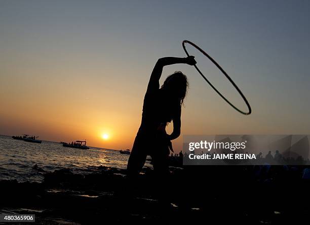 Woman dances during sunset at Cafe del Mar in San Antonio de Portmany, on Ibiza Island on July 10, 2015. AFP PHOTO/ JAIME REINA