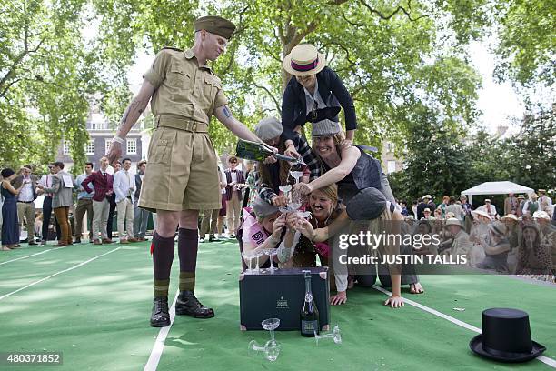 Participants in period costumes take part in the Champagne Charlie Pyramid of Dextrous Dandies competition during "The Chap Olympiad" in central...