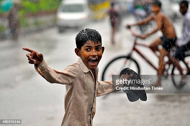 Children enjoy during heavy rain on July 11, 2015 in Noida, India. Heavy rain in Delhi/NCR brings the mercury down and causes water logging in many...
