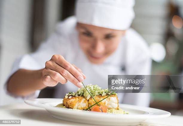 cook decorating a plate - voedselbereiding stockfoto's en -beelden