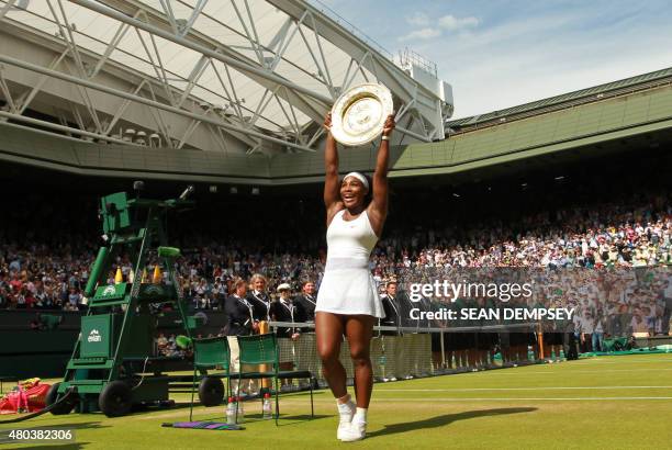 Player Serena Williams poses with the winner's trophy, the Venus Rosewater Dish, after her women's singles final victory over Spain's Garbine...