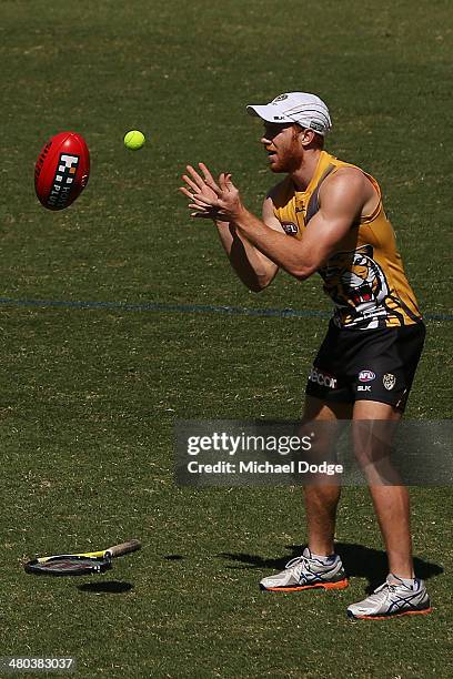 Todd Banfield catches and throws back a tennis ball and a football during a Richmond Tigers AFL training session at ME Bank Centre on March 25, 2014...