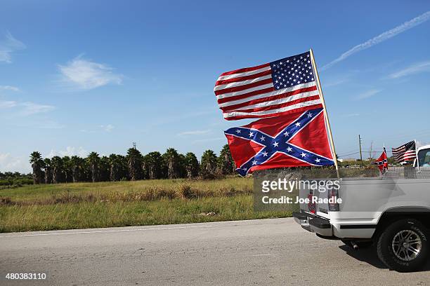 An American and Confederate flag fly from a vehicle during a rally to show support for the flags on July 11, 2015 in Loxahatchee, Florida. Organizers...
