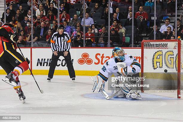 Mike Cammalleri of the Calgary Flames scores the game-winning goal against Alex Stalock of the San Jose Sharks during an NHL game at Scotiabank...