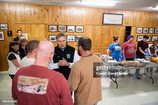 Washington Governor Jay Inslee speaks with Greg, Dan, and Kyle Regelbrugge at a temporary Red Cross shelter at the Darrington Community Center on...