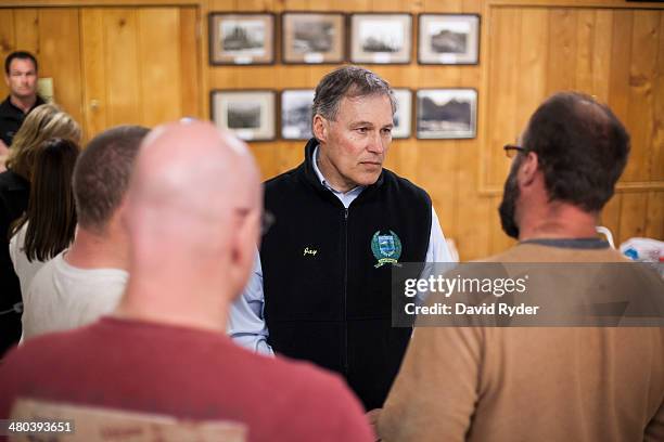 Washington Governor Jay Inslee speaks with Greg, Dan, and Kyle Regelbrugge at a temporary Red Cross shelter at the Darrington Community Center on...