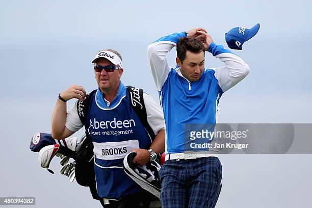 Wind blows the hat off the head of Daniel Brooks of England as he walks with his caddie on the ninth hole during the third round of the Aberdeen...