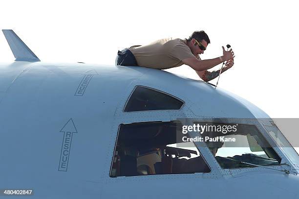 Ground crew member services a P3 Orion at RAAF Base Pearce on March 24, 2014 in Perth, Australia. French authorities reported a satellite sighting of...