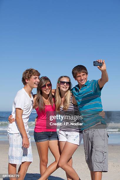 teens with phone on the beach - girls wearing hot pants stock pictures, royalty-free photos & images