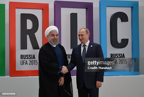 In this handout image supplied by Host Photo Agency/RIA Novosti, President of the Russian Federation Vladimir Putin and President of the Islamic...