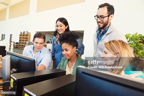 diverse group of adult college students using computer together - mature student stock pictures, royalty-free photos & images