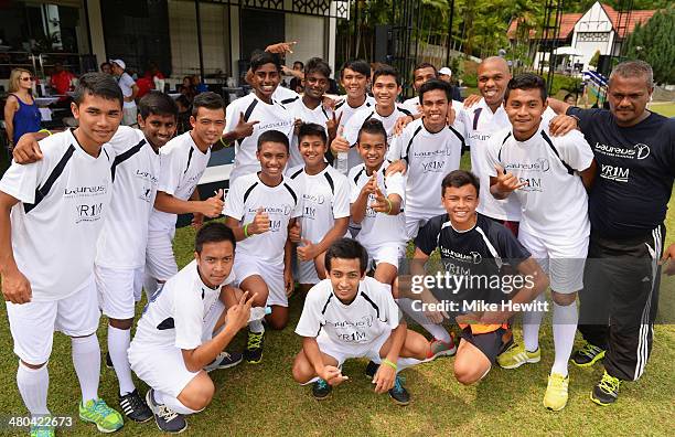 Quinton Fortune poses with U19 players during the Laureus All Stars Unity Cup ahead of the 2014 Laureus World Sports Awards at Royal Selangor Club on...