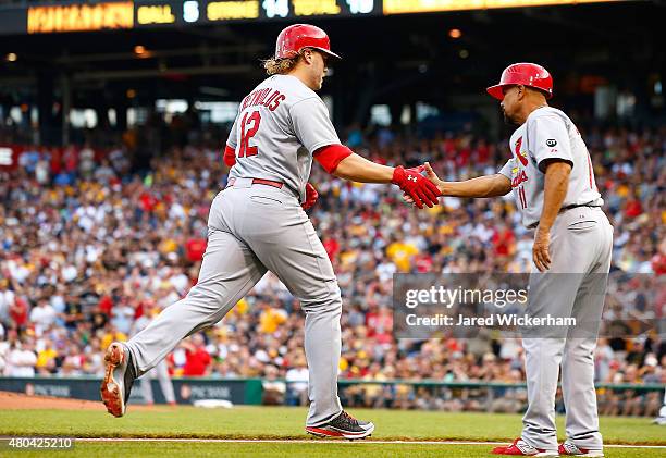 Mark Reynolds of the St Louis Cardinals is congratulated by Jose Oquendo after hitting a solo home run in the second inning against the Pittsburgh...