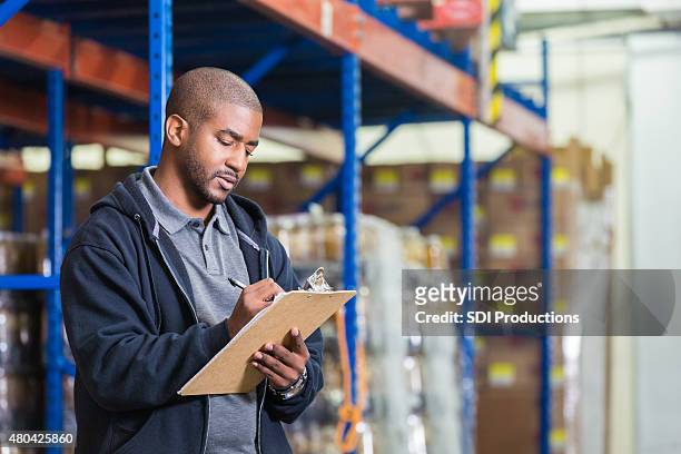 warehouse manager taking inventory in food bank pantry - warehouse inventory stock pictures, royalty-free photos & images