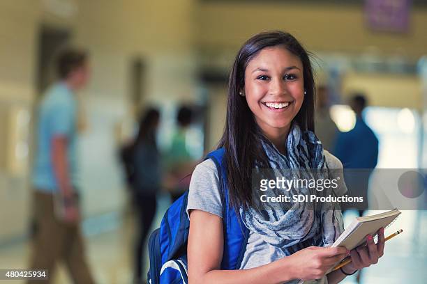 hispanic adolescente femmina studente di scuola secondaria sorridenti nel corridoio - studentessa di scuola secondaria foto e immagini stock