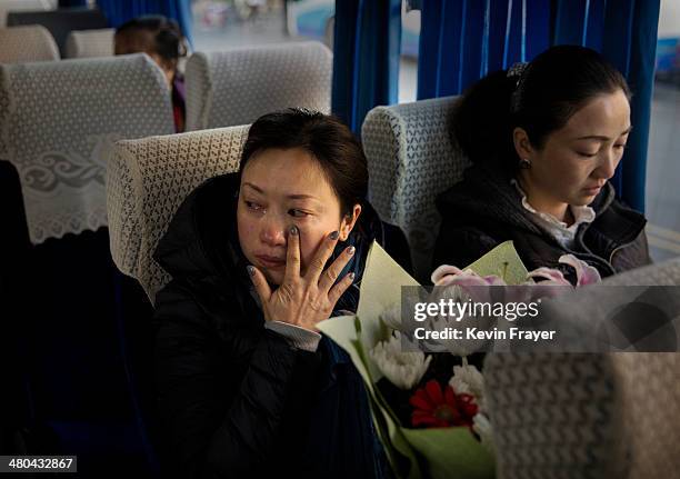 Chinese woman cries as she waits in a bus to be taken to a sea burial ceremony organized by the Funeral and Internment Administration of Shanghai...