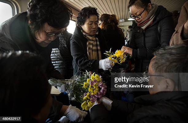 Relatives place flower petals in a bag carrying the ashes of a relative during a sea burial organized by the Funeral and Internment Administration of...