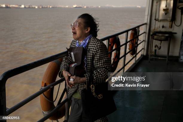 Lin Hui Zhen, 76 years, weeps as she clutches the small bag carrying the ashes of her late husband Fu Yao Ming, 80 years, during a sea burial...