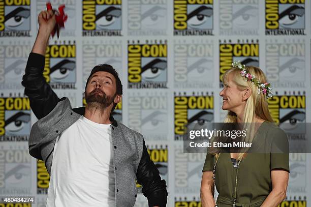 Actor Richard Armitage throws a flower crown to fans as producer Martha De Laurentiis looks on during the "Hannibal" Savor the Hunt panel during...