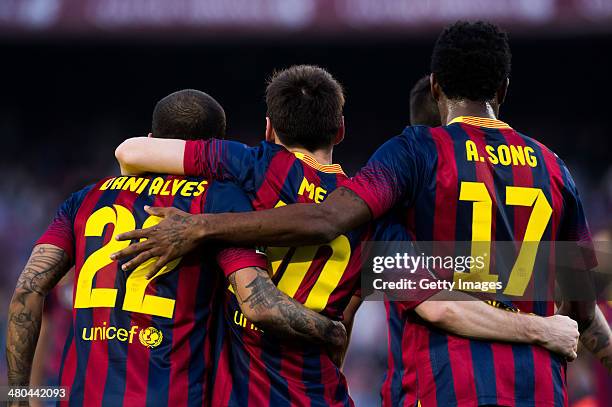 Lionel Messi of FC Barcelona celebrates with his teammates Daniel Alves and Alex Song after scoring his team's sixth goal during the La Liga match...