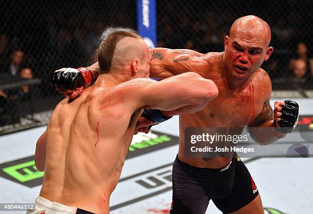 Punches Rory MacDonald in their UFC welterweight title fight during the UFC 189 event inside MGM Grand Garden Arena on July 11, 2015 in Las Vegas,...