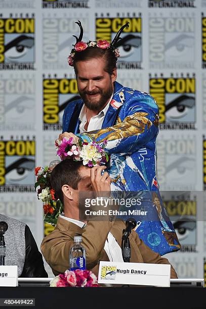 Executive producer/creator Bryan Fuller puts a flower crown on actor Hugh Dancy at the "Hannibal" Savor the Hunt panel during Comic-Con International...