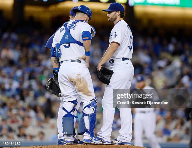 Starting pitcher Brandon Beachy gets a visit from catcher Yasmani Grandal and pitching coach Rick Honeycutt after giving up a three-run double to...