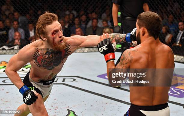 Conor McGregor punches Chad Mendes in their UFC interim featherweight title fight during the UFC 189 event inside MGM Grand Garden Arena on July 11,...