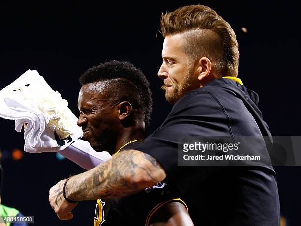 Andrew McCutchen of the Pittsburgh Pirates is smeared with whipped cream in the face by teammate A.J. Burnett after hitting the game-winning two run...
