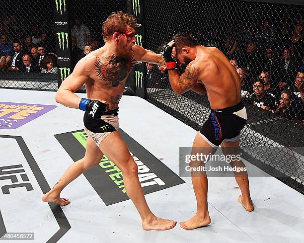 Conor McGregor punches Chad Mendes in their UFC interim featherweight title fight during the UFC 189 event inside MGM Grand Garden Arena on July 11,...