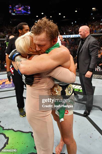 Conor McGregor celebrates with a family member after his victory over Chad Mendes in their UFC interim featherweight title fight during the UFC 189...