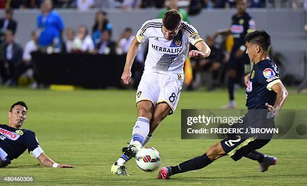 In his MLS debut, Liverpool FC legend Steven Gerrard of the LA Galaxy shoots under pressure from Paolo Goltz of Club America during their 2015...