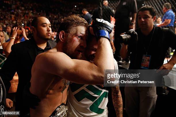 Conor McGregor exits the Octagon with a teammate after his UFC interim featherweight title fight during the UFC 189 event inside MGM Grand Garden...