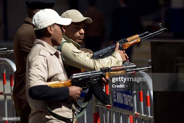 Egyptian policemen stand guard outside the courthouse on March 25, 2014 in the central Egyptian city of Minya, during a session of the trial of some...