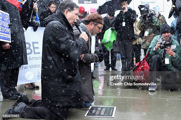 Father Frank Pavone and Rev. Patrick Mahoney pray on their knees during a rally outside of the U.S. Supreme Court during oral arguments in Sebelius...