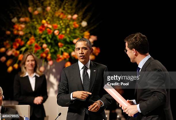 Dutch Prime Minister Mark Rutte, right, hands over a symbolic stick to U.S. President Barack Obama at the closing session of the 2014 Nuclear...